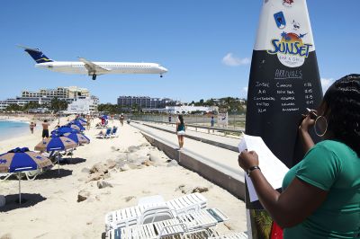 Woman updating arrivals on the Sunset beach bar board